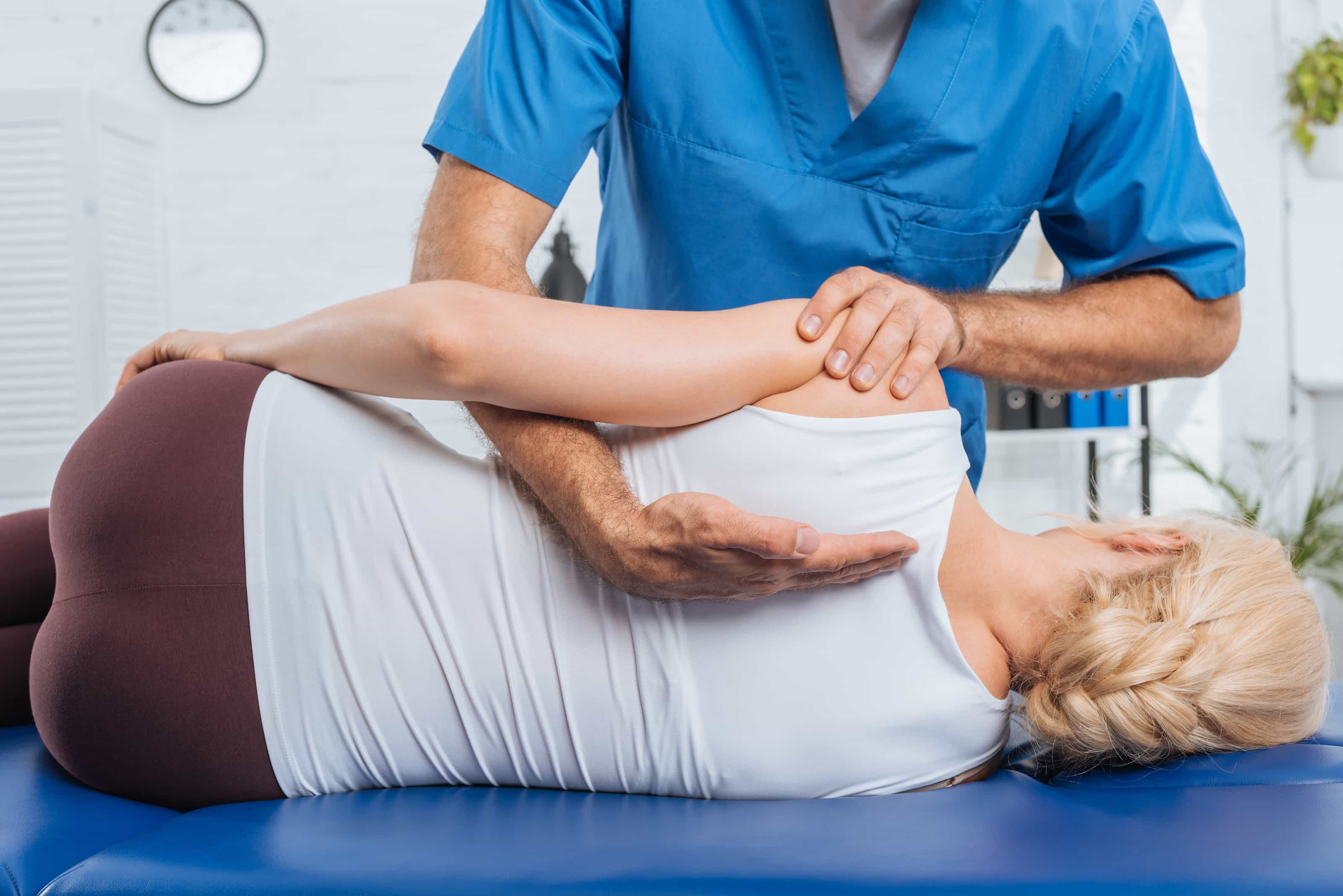 Chiropractor giving a back adjustment to a woman